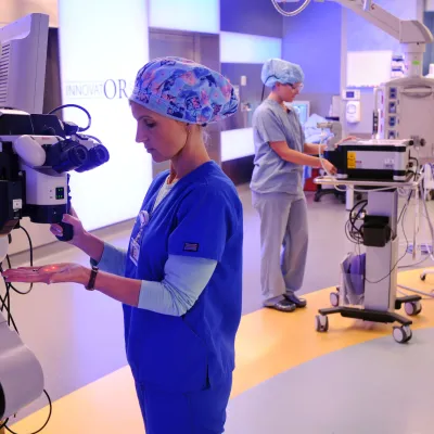 Medical specialists work with robotic surgery equipment.