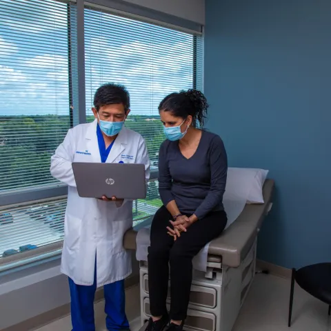 Dr. Sucandy showing a patient slides on his computer