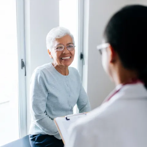 elderly woman talking to a doctor in a doctors office