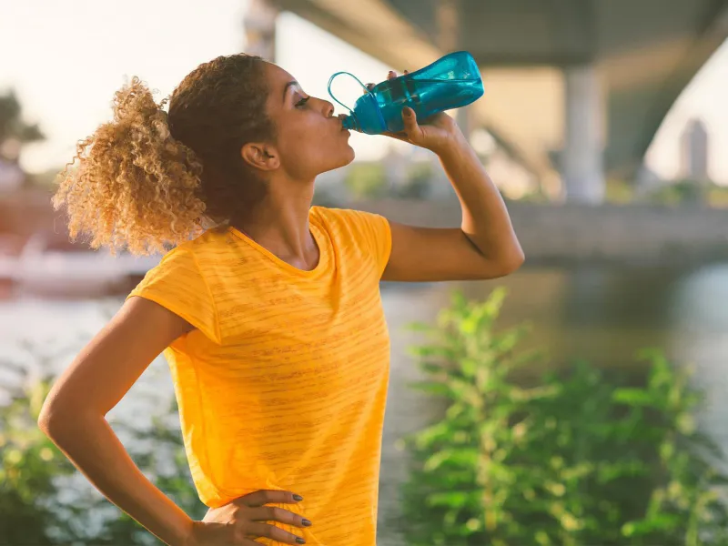 Woman on a run drinking water 