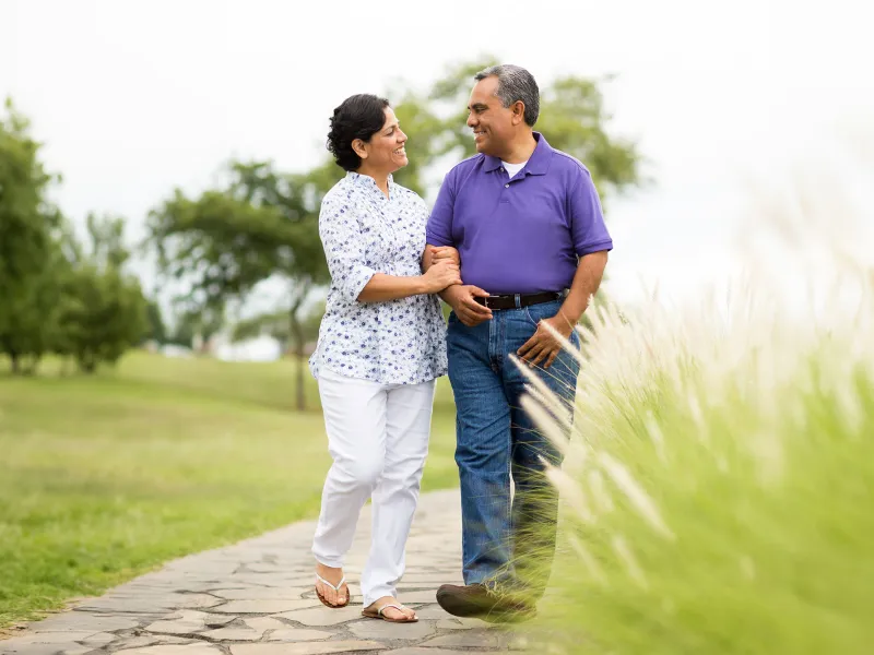 hispanic couple walking along a park path