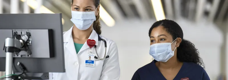 Two female physicians looking at a computer