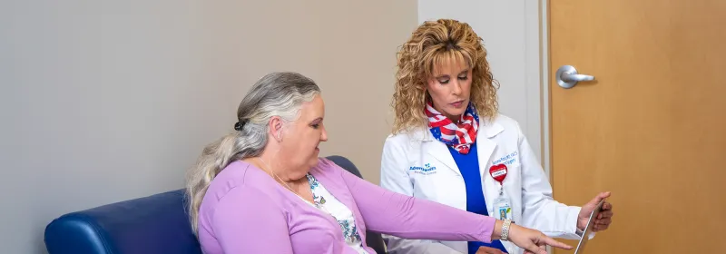 Sandra Freeman with patient looking at a laptop.